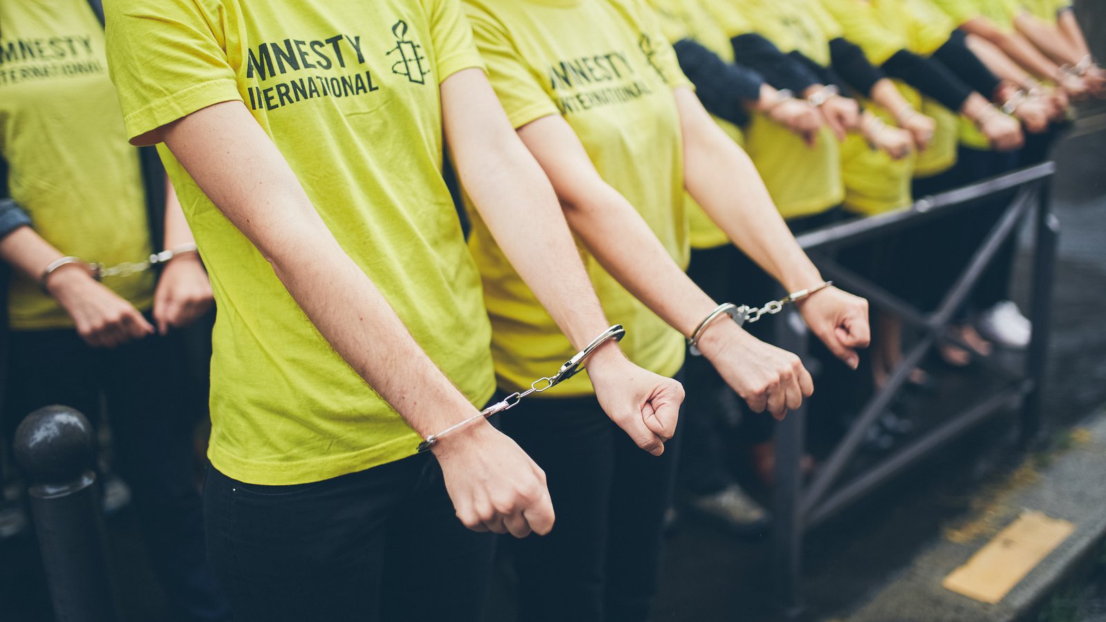 Demonstranter med symboliska handbojor