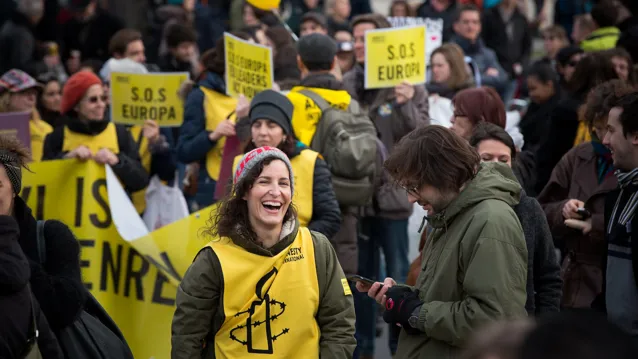 Demonstrant med amnesty väst och stort leende